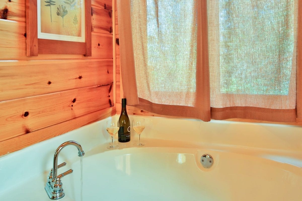 Yellowstone Loft bathtub with wine glasses and wine bottle.