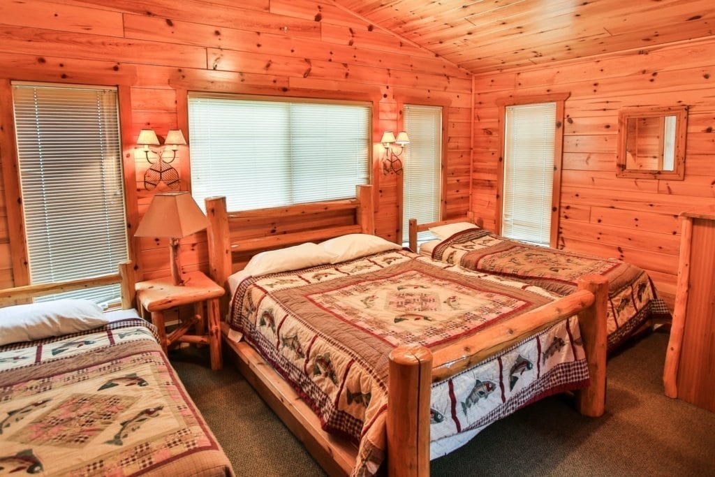 Firestone Log Lodge bedroom with three beds.