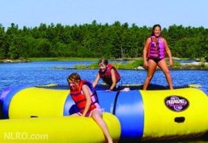 Young girls playing on water trampoline.