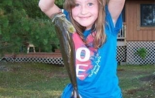Young girl holding a fish.