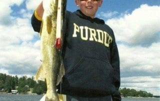 Young man holding a large fish.