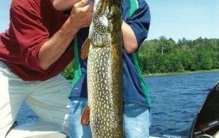 Boy and adult holding a large pike.