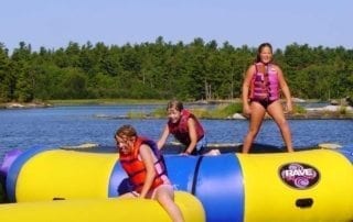 Young girls on aqua trampoline.